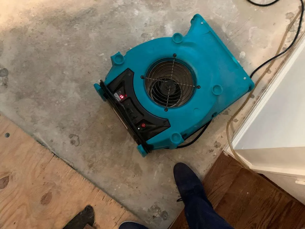 Air mover drying subfloor during Commercial Water Damage Restoration in Snyderville